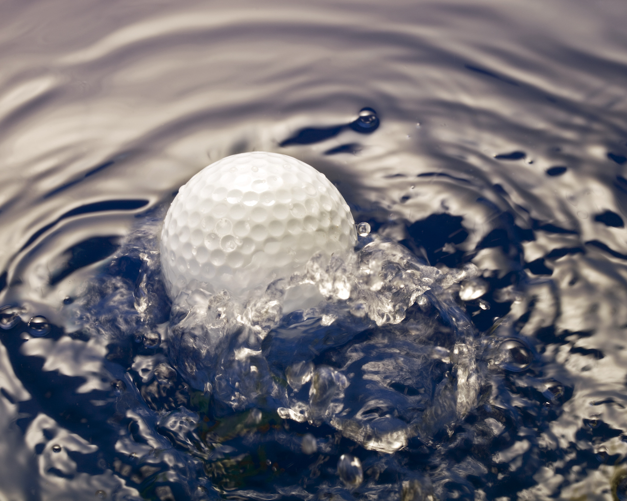 Golf ball splashing in water