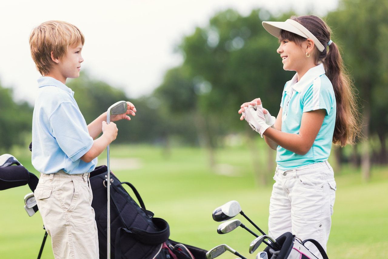 kids with golf clubs on course