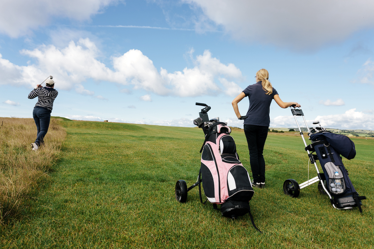 Golfers using push carts on course