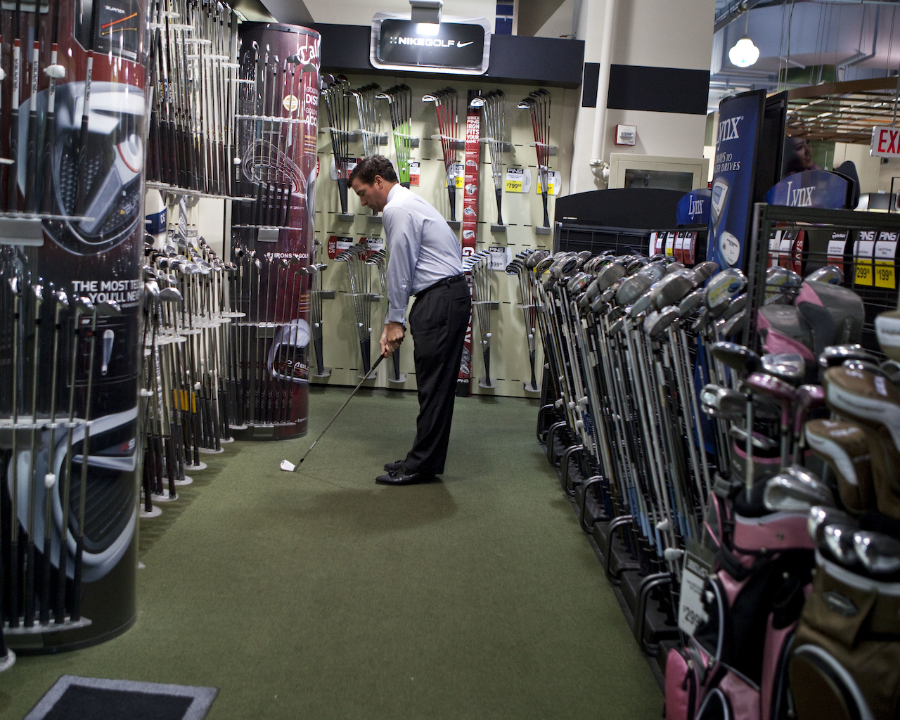 Golfer shopping for clubs in store