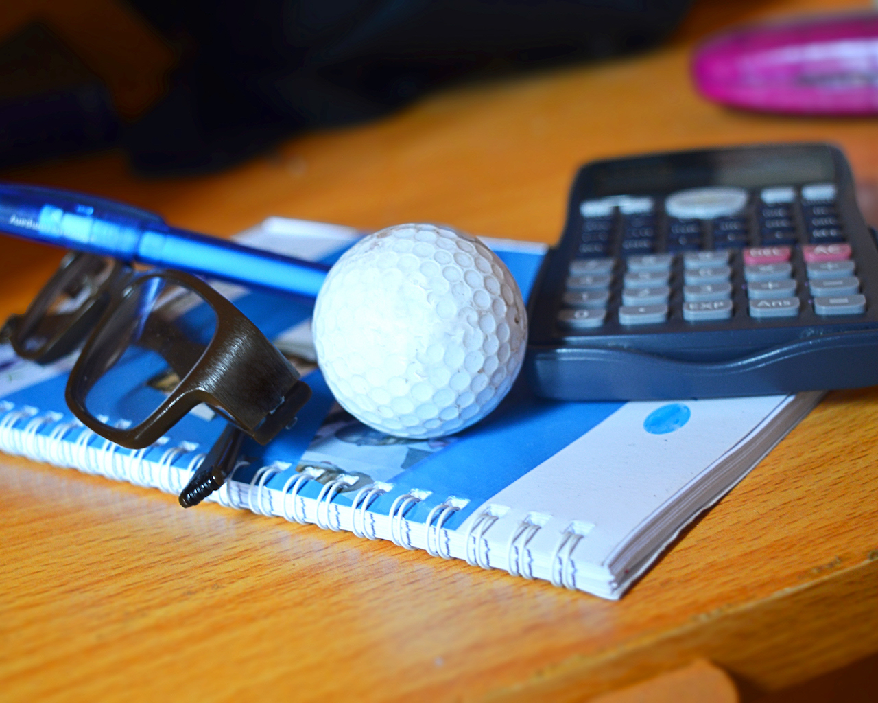 golf ball calculator notepad on table
