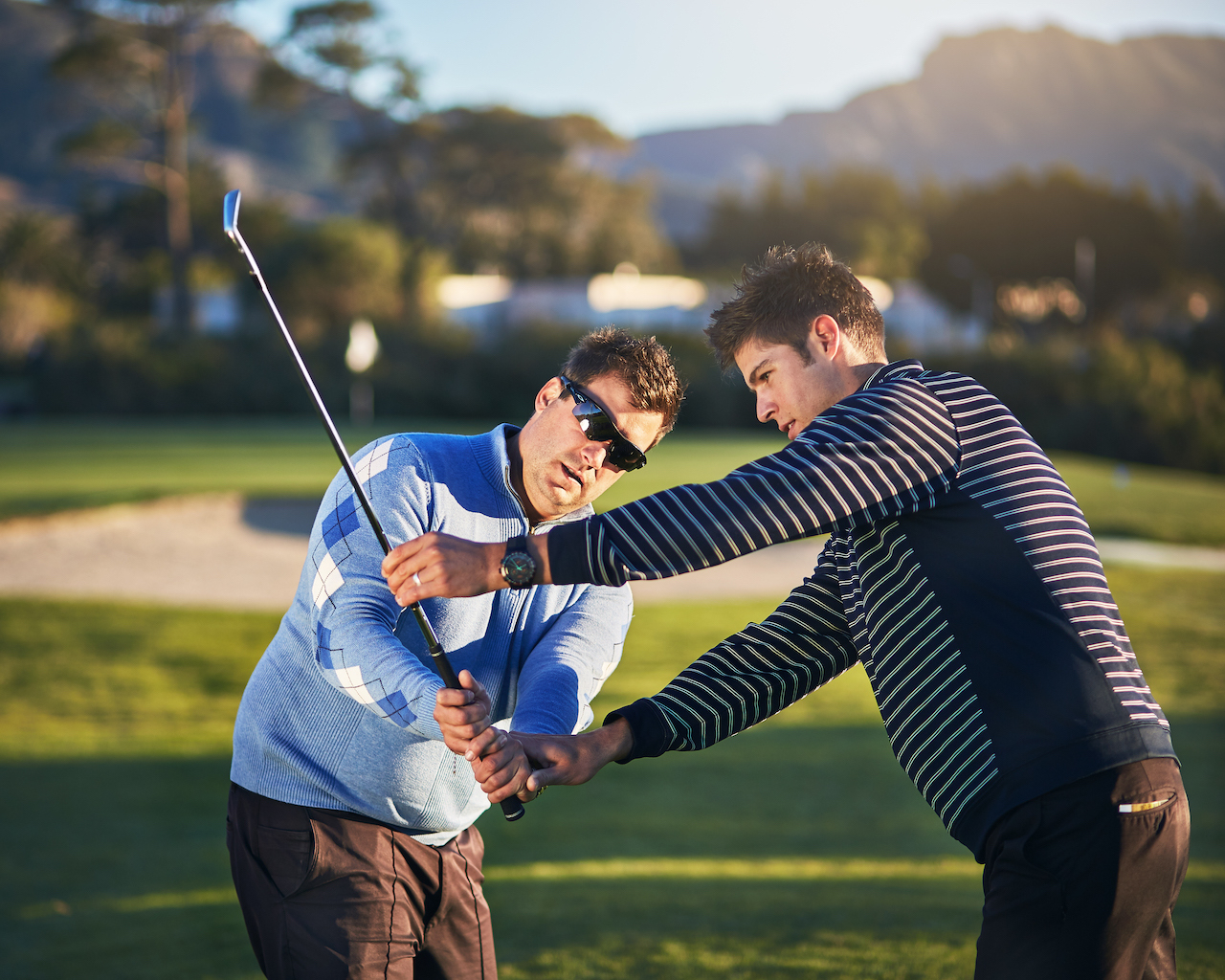 Instructor giving golfer lessons