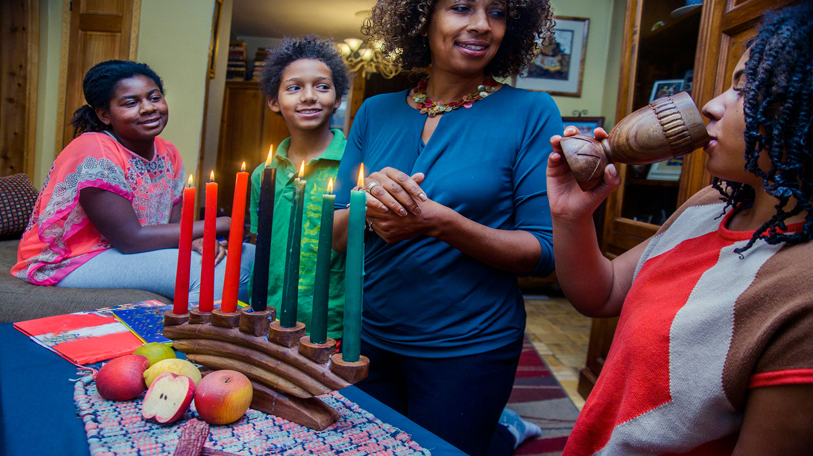 family celebrating with Kwanzaa unity cup
