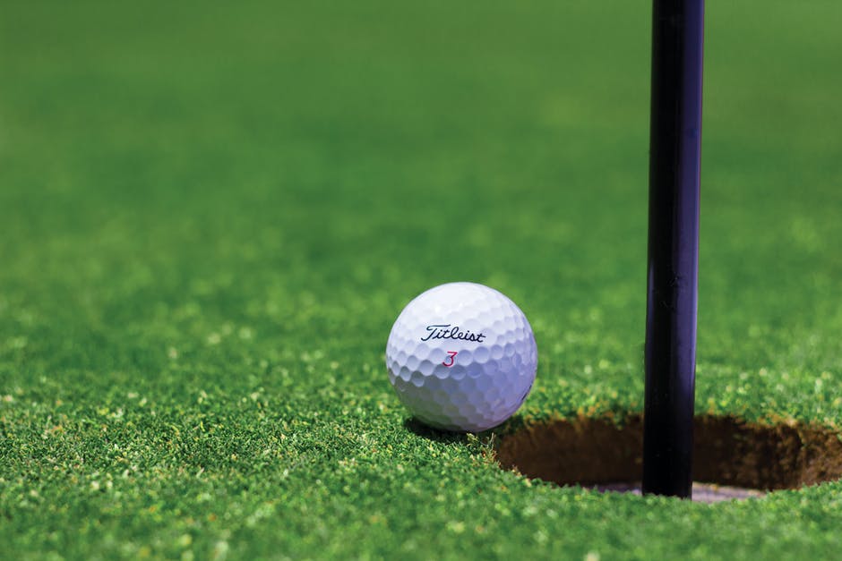Titrist Golf Ball Near Golf Hole Titrist Golf Ball Near Golf Hole