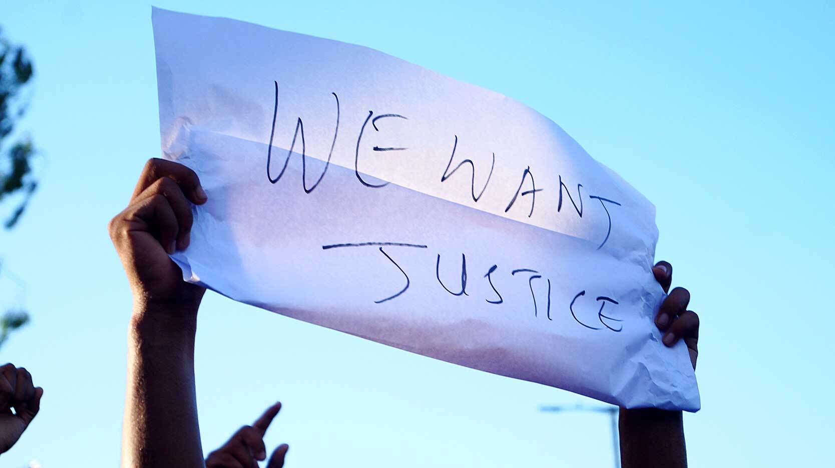 protest sign with words we want justice