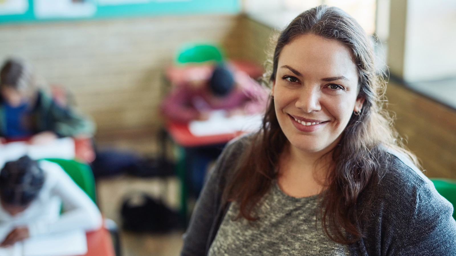 confident smiling woman teacher in classroom